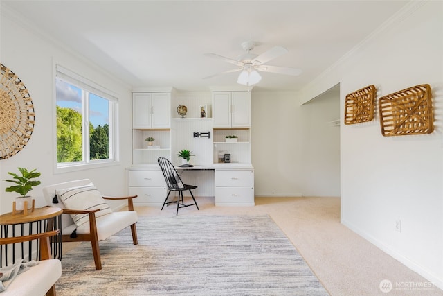 office space with light colored carpet, ornamental molding, and a ceiling fan