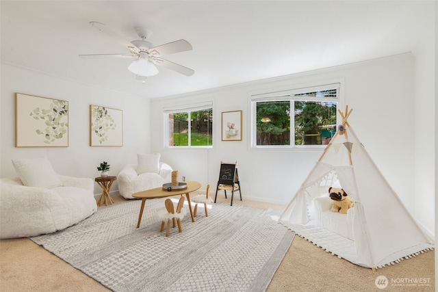 interior space with baseboards, ornamental molding, carpet, and a ceiling fan