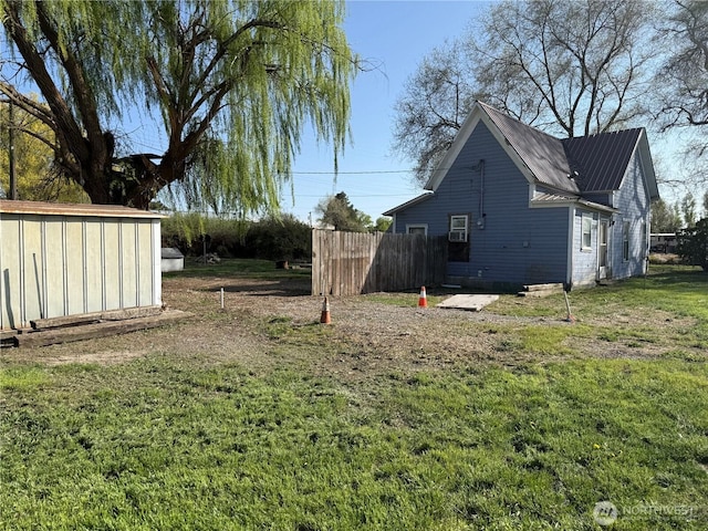 view of yard featuring fence, an outdoor structure, and a shed