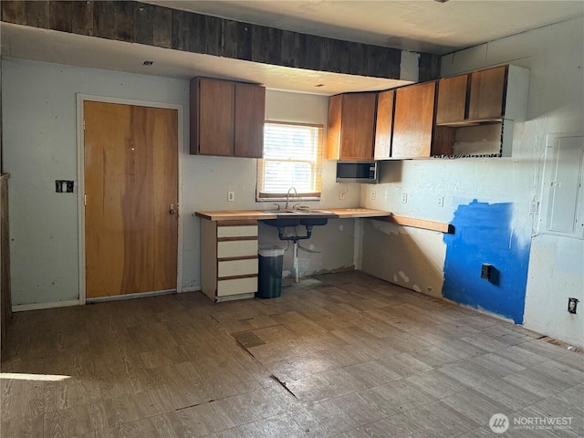 kitchen with tile patterned floors, a sink, light countertops, and stainless steel microwave