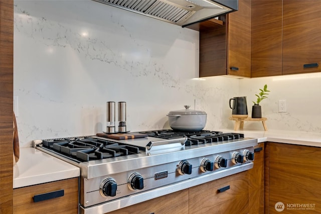 909 11th St, Mukilteo, WA 98275 - kitchen with decorative backsplash, stainless steel gas stovetop, modern cabinets, range hood, and brown cabinetry