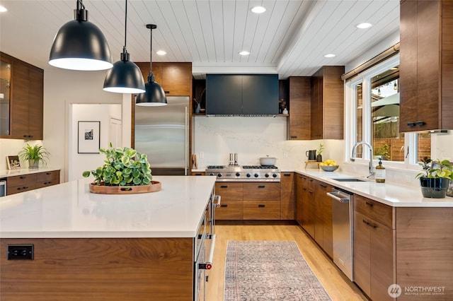 909 11th St, Mukilteo, WA 98275 - kitchen with recessed lighting, a sink, brown cabinetry, light wood-type flooring, and appliances with stainless steel finishes