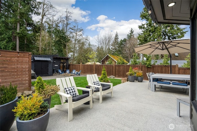 909 11th St, Mukilteo, WA 98275 - view of patio with an outbuilding, a storage unit, and a fenced backyard