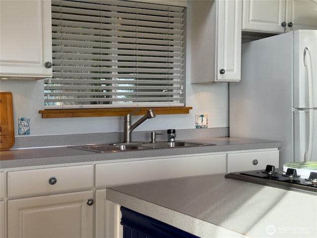 36 K Beach Way, Hat Island, WA 98206 - kitchen with freestanding refrigerator, a sink, white cabinetry, and stovetop