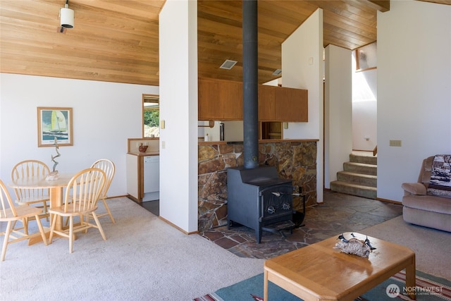 carpeted living room with baseboards, a wood stove, lofted ceiling, and wood ceiling