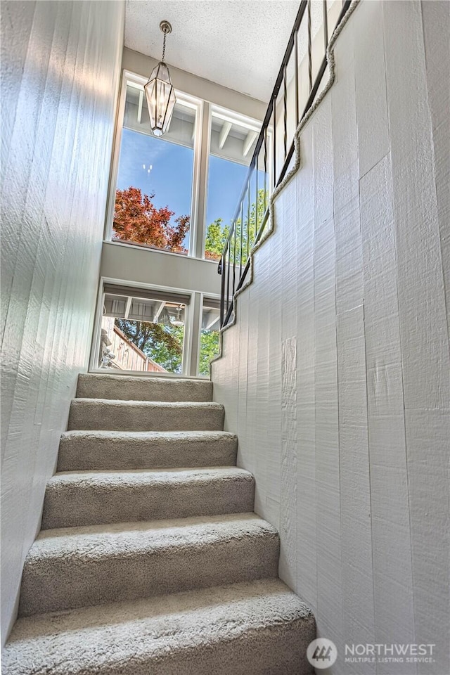 staircase with a chandelier
