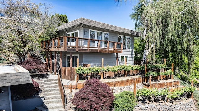 back of house with a wooden deck, a shingled roof, and mansard roof