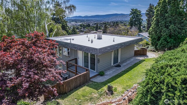 view of home's exterior with a mountain view, a chimney, and a yard