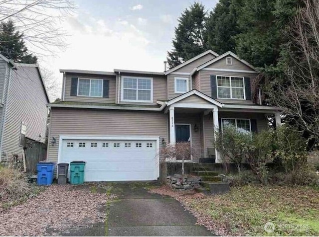 craftsman-style home featuring an attached garage and aphalt driveway