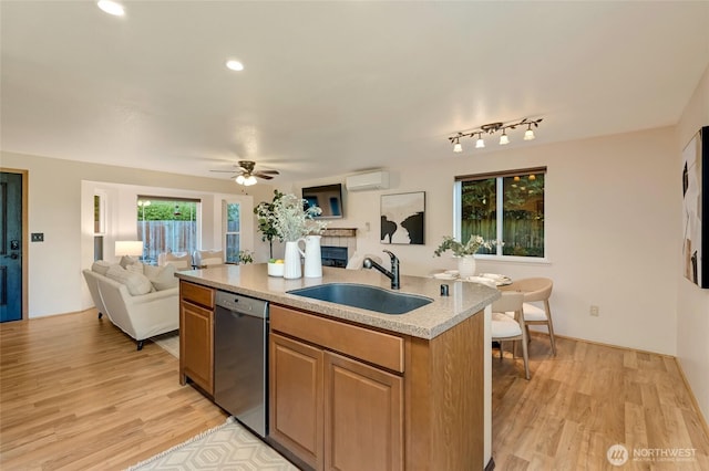 kitchen featuring a sink, a fireplace, open floor plan, stainless steel dishwasher, and a wall mounted AC