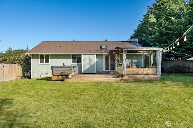 rear view of house with a lawn, fence, and a wooden deck