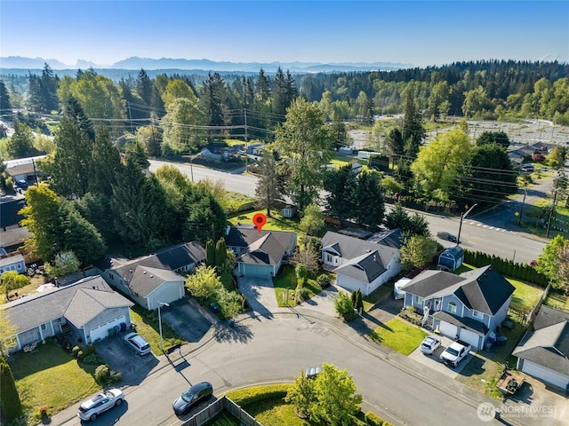 bird's eye view featuring a view of trees, a mountain view, and a residential view