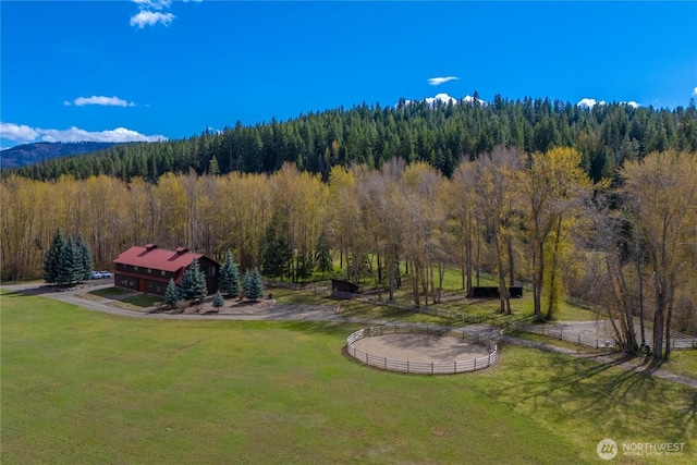 exterior space with a forest view and fence
