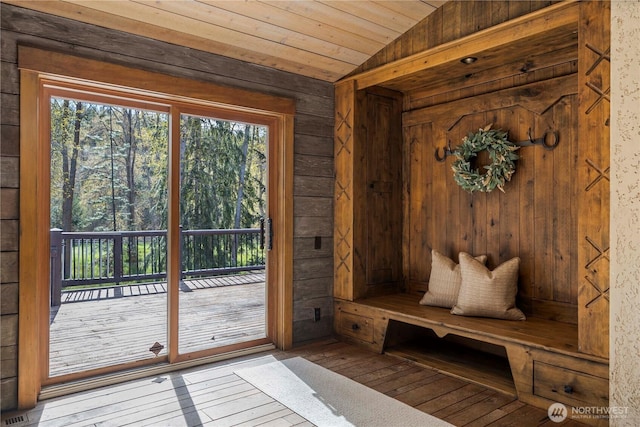 interior space with wood-type flooring, wood walls, vaulted ceiling, and wood ceiling