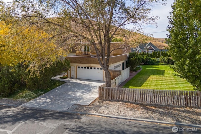 view of front of house with a front yard, driveway, a garage, and fence