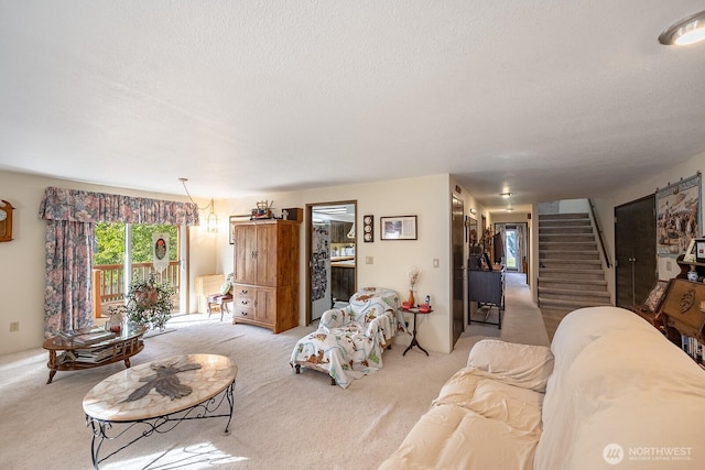 carpeted living room featuring stairs and a textured ceiling