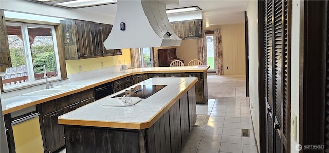kitchen featuring black appliances, range hood, a sink, and tile countertops