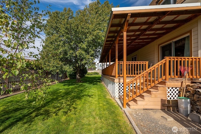 view of yard with a deck, stairs, and fence