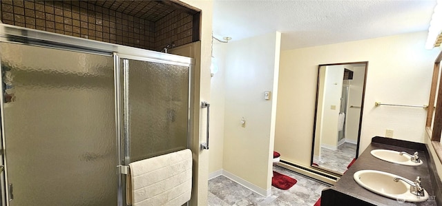 bathroom featuring a sink, a shower stall, and baseboards