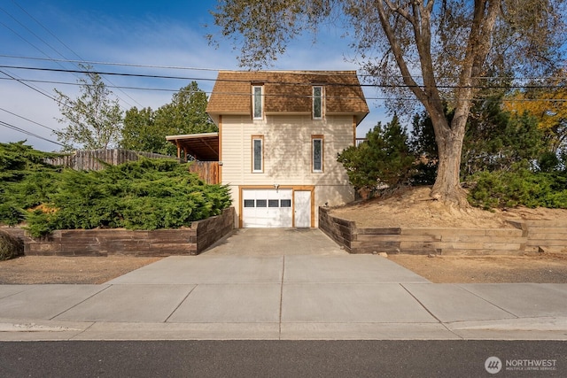 view of front of house with concrete driveway, a shingled roof, an attached garage, and mansard roof