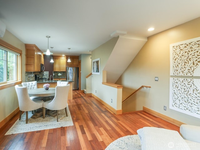 dining room featuring baseboards, recessed lighting, and light wood finished floors