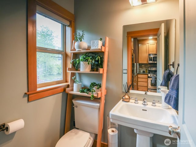bathroom featuring decorative backsplash, a sink, and toilet
