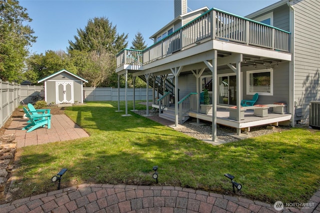 rear view of house with a deck, an outbuilding, a shed, and a fenced backyard