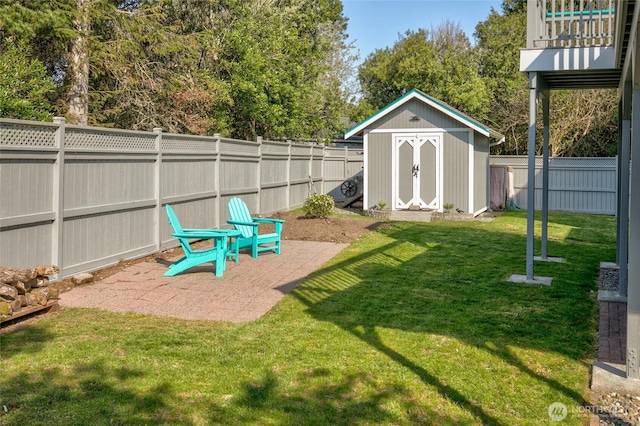 view of playground with a patio area, an outbuilding, a fenced backyard, a lawn, and a storage unit