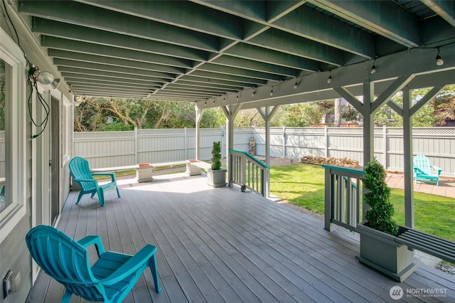 wooden terrace with a lawn and a fenced backyard