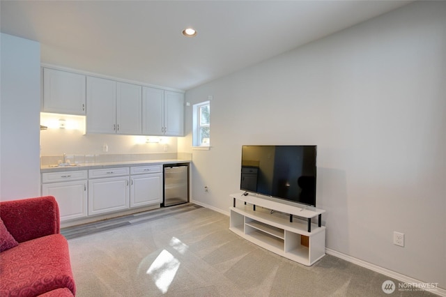 living room featuring baseboards, recessed lighting, and light carpet