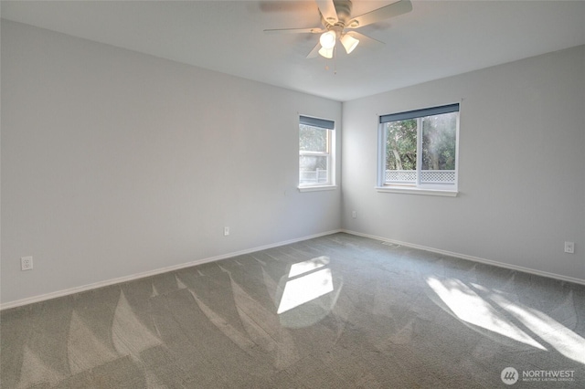 carpeted empty room with ceiling fan and baseboards