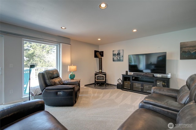 carpeted living area with a wood stove, recessed lighting, and baseboards