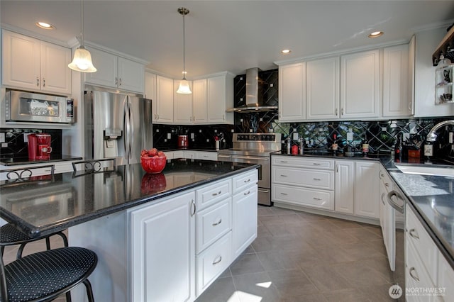 kitchen featuring wall chimney range hood, white cabinetry, a sink, stainless steel appliances, and tile patterned floors
