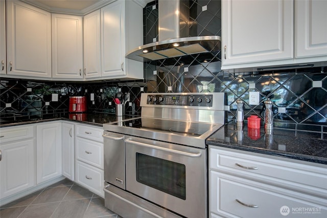 kitchen with wall chimney exhaust hood, double oven range, and white cabinetry