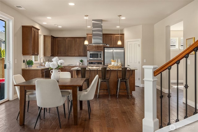 dining room featuring visible vents, plenty of natural light, stairway, and dark wood-type flooring