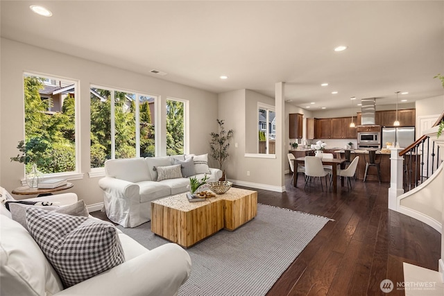 living area with dark wood-style flooring, recessed lighting, baseboards, visible vents, and stairway