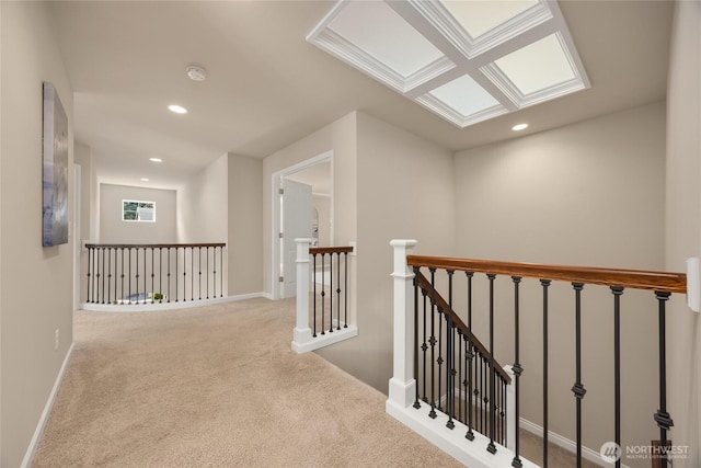 hall with carpet flooring, recessed lighting, baseboards, and an upstairs landing