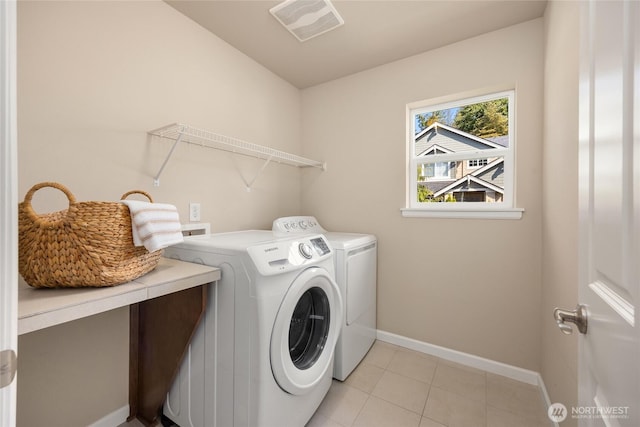 laundry area with independent washer and dryer, light tile patterned flooring, laundry area, baseboards, and visible vents