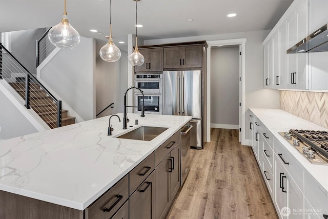 1343 211th Ave NE, Sammamish, WA 98074 - kitchen with appliances with stainless steel finishes, range hood, dark brown cabinets, light wood finished floors, and recessed lighting