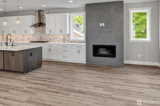 1343 211th Ave NE, Sammamish, WA 98074 - kitchen featuring wall chimney exhaust hood, white cabinets, light countertops, light wood finished floors, and recessed lighting