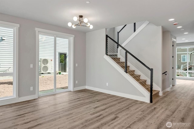 1343 211th Ave NE, Sammamish, WA 98074 - unfurnished living room with light wood-style flooring, a chandelier, stairs, plenty of natural light, and recessed lighting