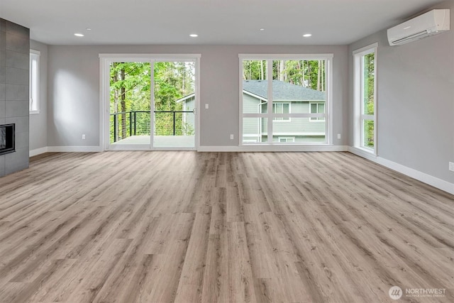 1343 211th Ave NE, Sammamish, WA 98074 - unfurnished living room featuring a wall unit AC, healthy amount of natural light, light wood-style floors, a tile fireplace, and recessed lighting
