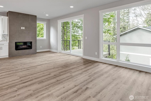 1343 211th Ave NE, Sammamish, WA 98074 - unfurnished living room featuring light wood-type flooring, recessed lighting, and a tiled fireplace