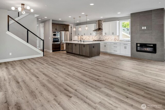 1343 211th Ave NE, Sammamish, WA 98074 - kitchen featuring wall chimney exhaust hood, open floor plan, stovetop, light countertops, and recessed lighting