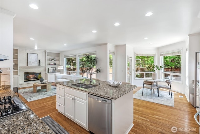 16639 Northup Way, Bellevue, WA 98008 - kitchen featuring appliances with stainless steel finishes, recessed lighting, white cabinets, light wood finished floors, and a fireplace
