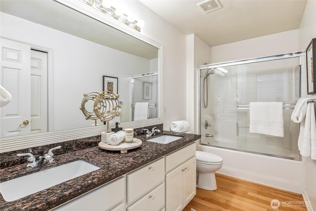 16639 Northup Way, Bellevue, WA 98008 - full bath with double vanity, enclosed tub / shower combo, and wood finished floors