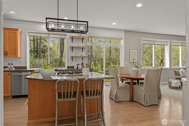 kitchen with dark countertops, stainless steel dishwasher, recessed lighting, and light wood finished floors