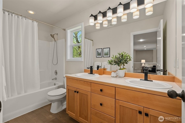 full bathroom with double vanity, a sink, shower / bath combo, and toilet