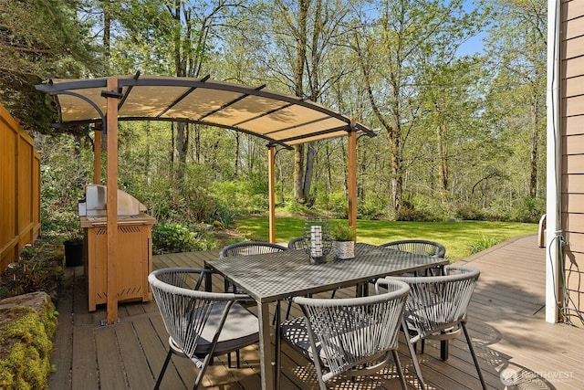 deck with grilling area, a yard, and outdoor dining space