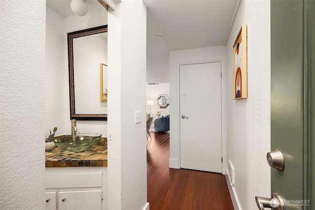 corridor with a sink and wood finished floors